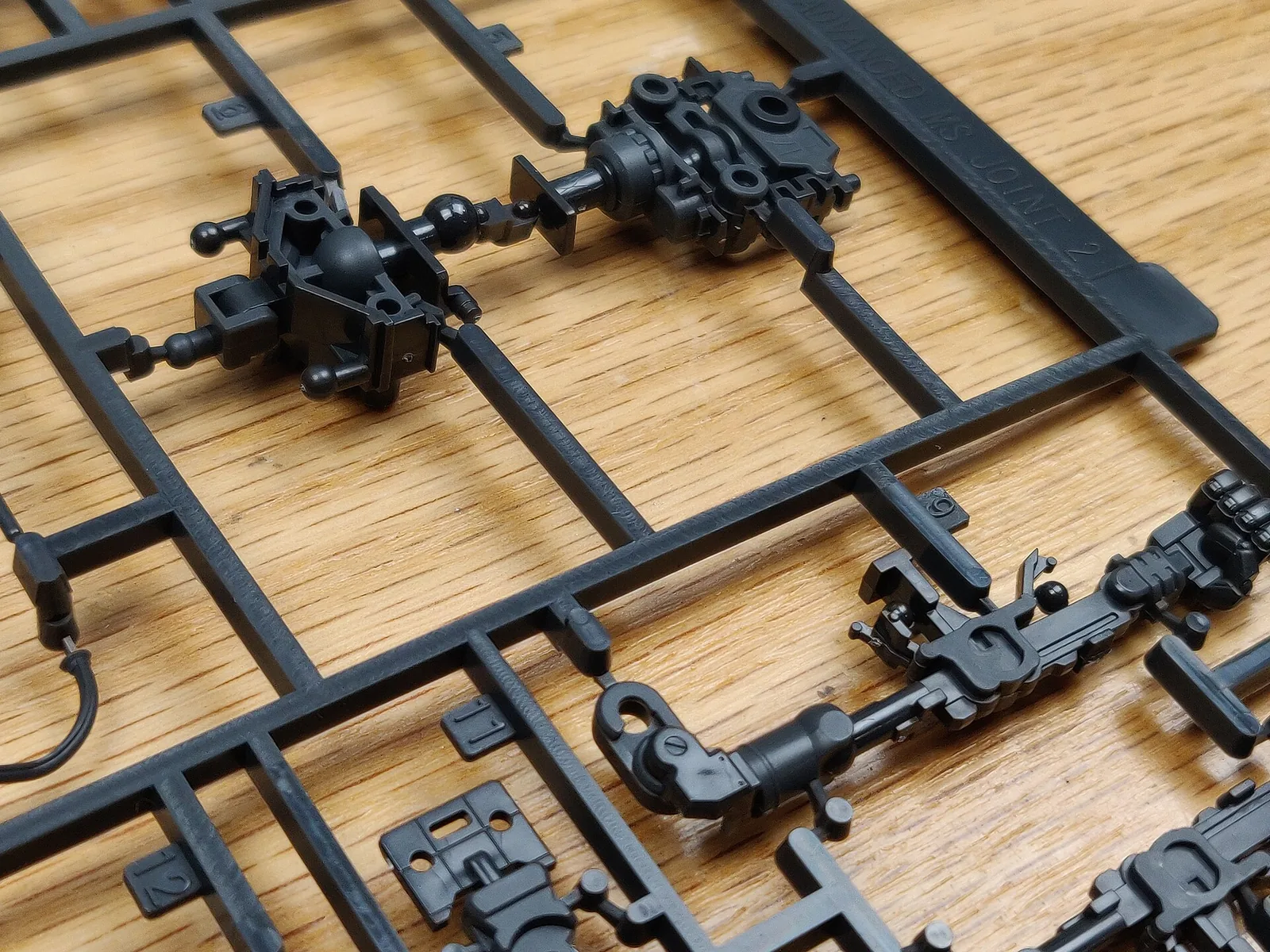 Real Grade Zaku II parts on runners, grey frame pieces next to green armor pieces in one tray