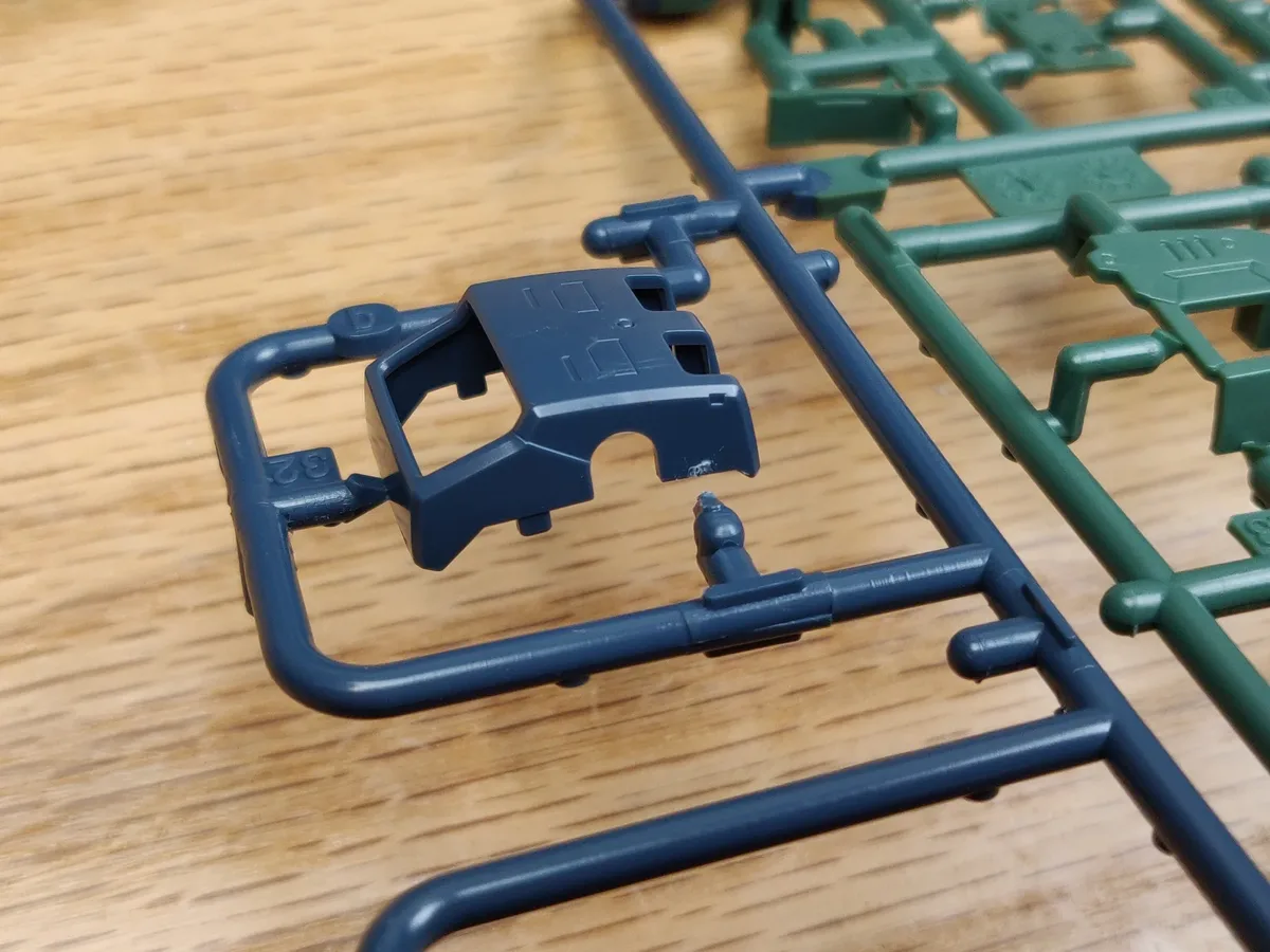 One part of a Real Grade Zaku II clipped from its runner, with a small nub of plastic left where the gate was cut